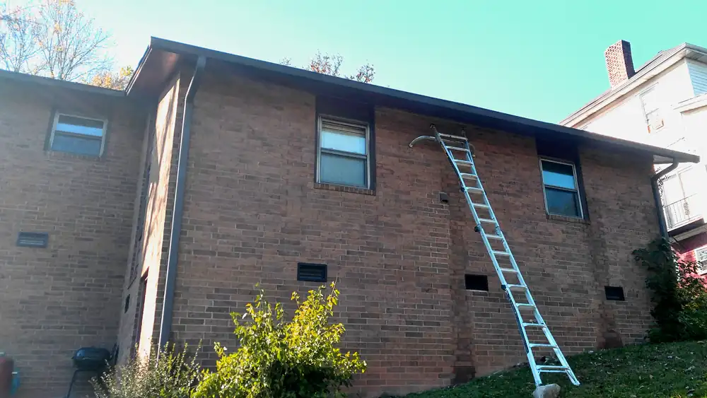 Brick house with new fascia boards and the continuous gutter rehung along the eave