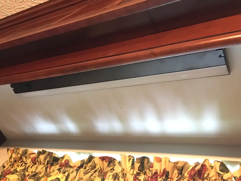 New LED strip fitted under a cherry kitchen cabinet, lighting the backsplash